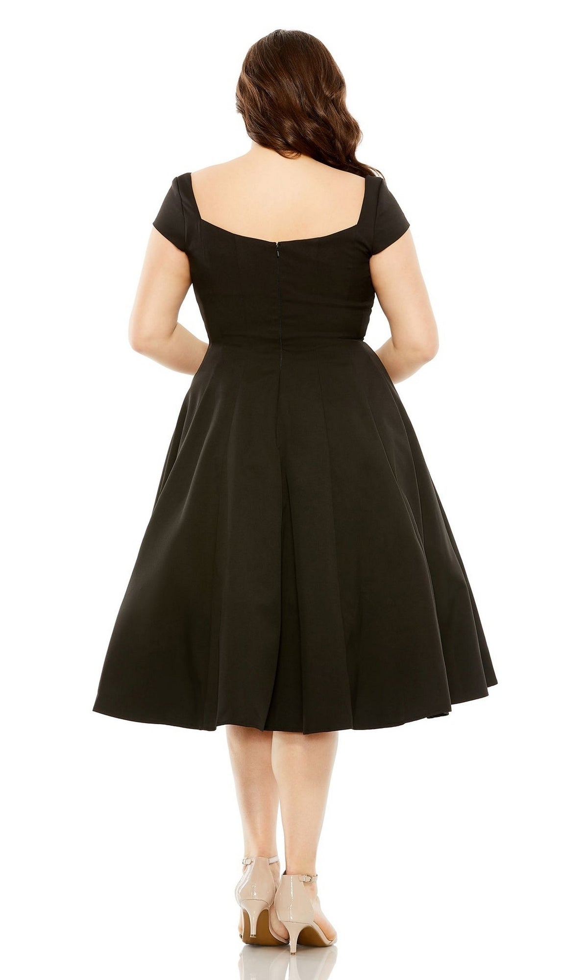 A woman faces away, wearing the Plus-Size Short Black Wedding-Guest Dress 49784W with short sleeves and beige heels against a plain white background.